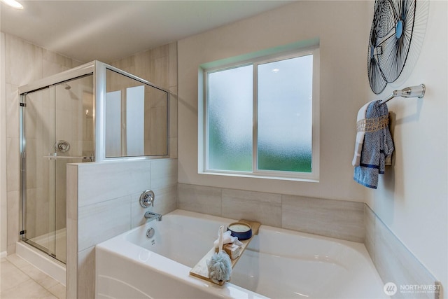 full bathroom with a stall shower, a bath, and tile patterned floors