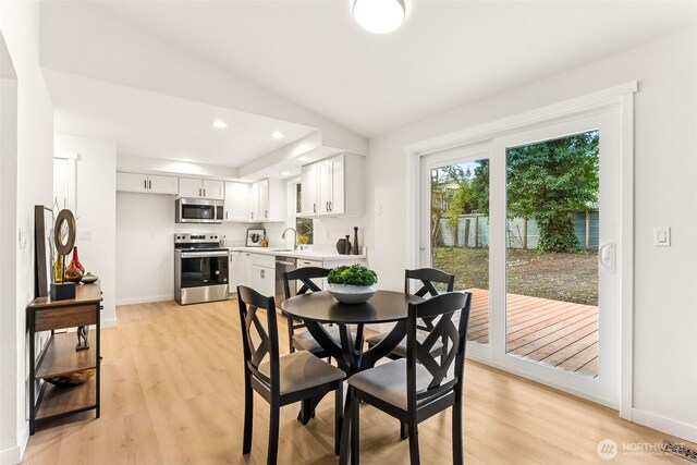 dining area with visible vents, baseboards, light wood-type flooring, lofted ceiling, and recessed lighting