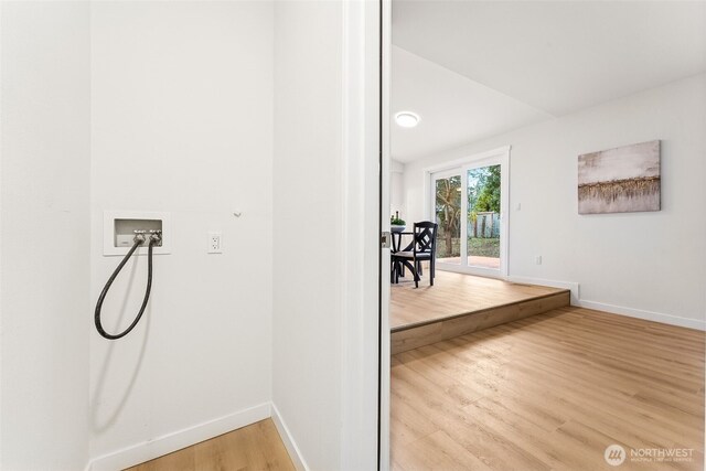 hall featuring light wood finished floors and baseboards