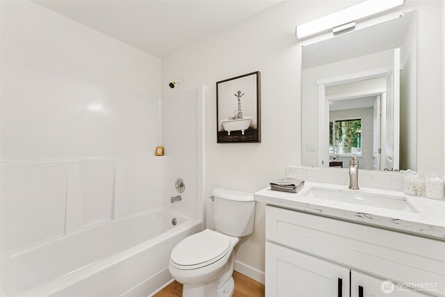 full bath featuring toilet, vanity, and bathing tub / shower combination