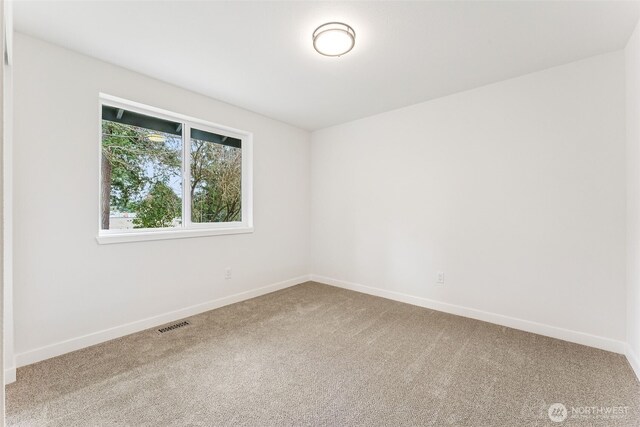 carpeted empty room featuring visible vents and baseboards