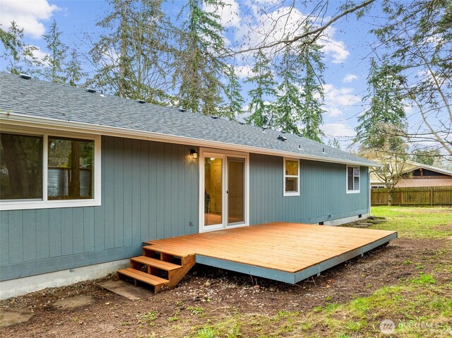 rear view of house with crawl space, a shingled roof, a deck, and fence