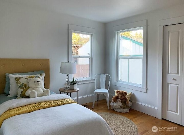 bedroom with light wood-type flooring and baseboards