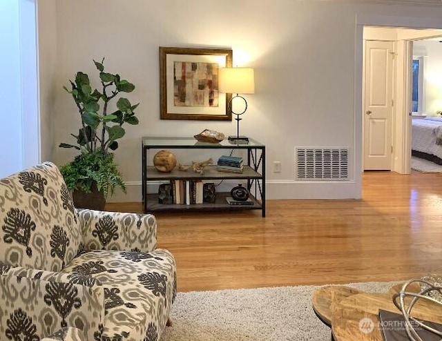 sitting room featuring wood finished floors, visible vents, and baseboards