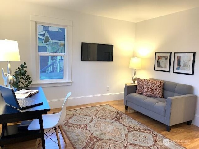 living area featuring baseboards and wood finished floors