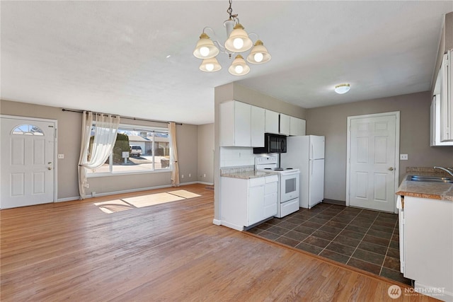 kitchen with white appliances, baseboards, white cabinets, light countertops, and dark wood finished floors