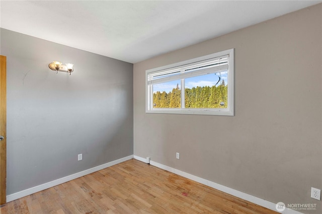 spare room featuring wood finished floors and baseboards