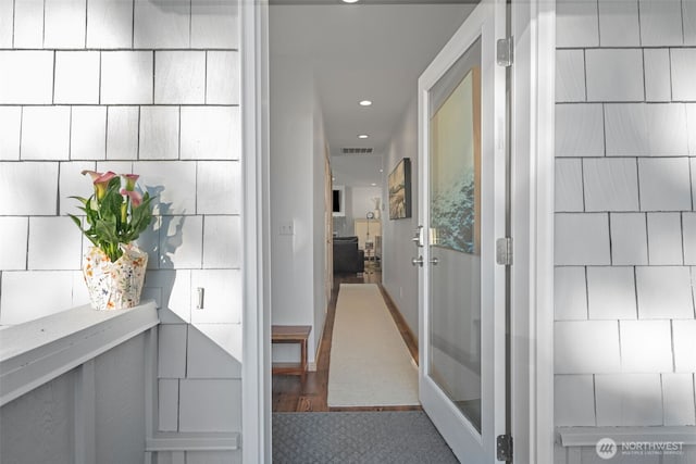 hall with recessed lighting, visible vents, and tile walls