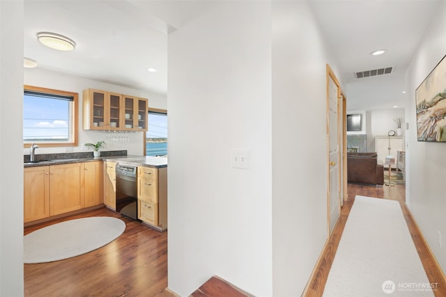 hall featuring recessed lighting, visible vents, a sink, and light wood finished floors