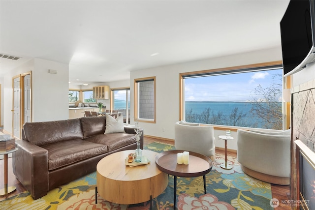 living room featuring baseboards, visible vents, and wood finished floors