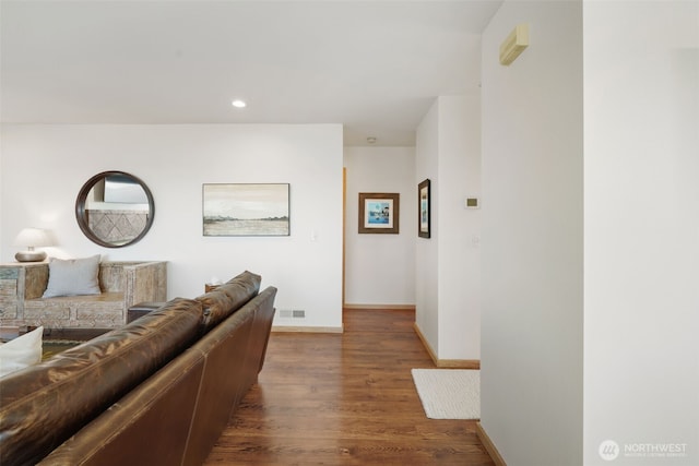 living area with recessed lighting, visible vents, baseboards, and wood finished floors