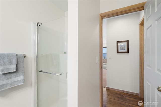 full bathroom featuring a stall shower and wood finished floors