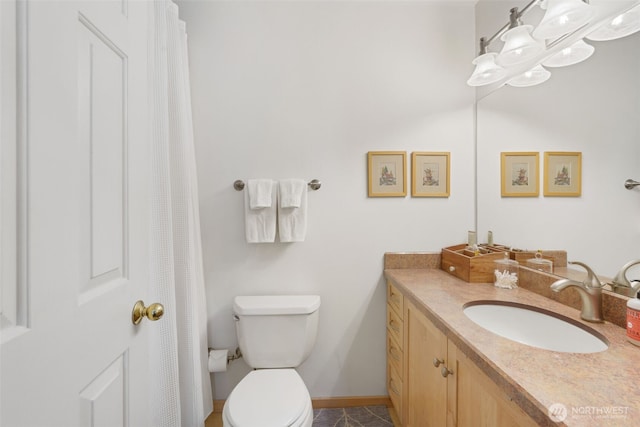 bathroom with baseboards, vanity, and toilet