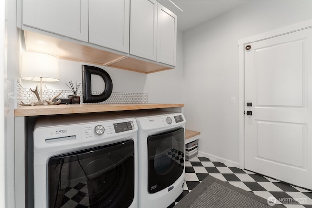 laundry room featuring washer and dryer, cabinet space, baseboards, and tile patterned floors