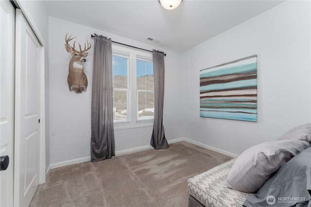 bedroom with a closet, carpet, visible vents, and baseboards