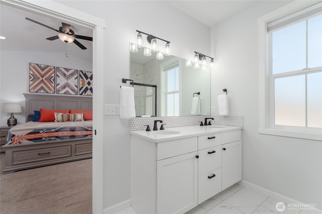 bathroom featuring tasteful backsplash, a stall shower, a sink, and connected bathroom