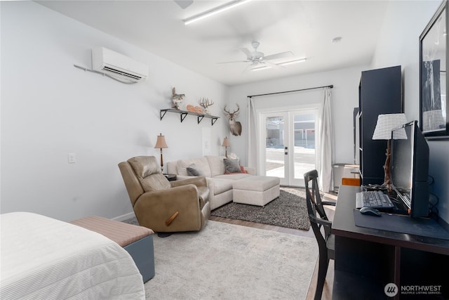 bedroom featuring wood finished floors, a ceiling fan, access to outside, french doors, and a wall mounted air conditioner