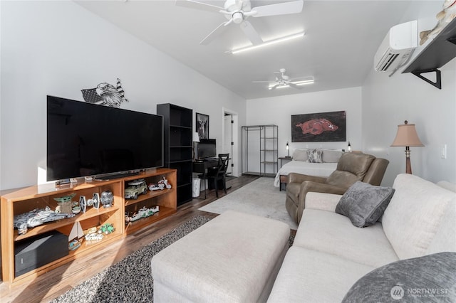 living area featuring ceiling fan, a wall mounted AC, and wood finished floors