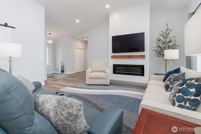422 Sunny Brooke Ln, Chelan, WA 98816 - living area featuring vaulted ceiling, light wood-style flooring, recessed lighting, a fireplace, and a barn door