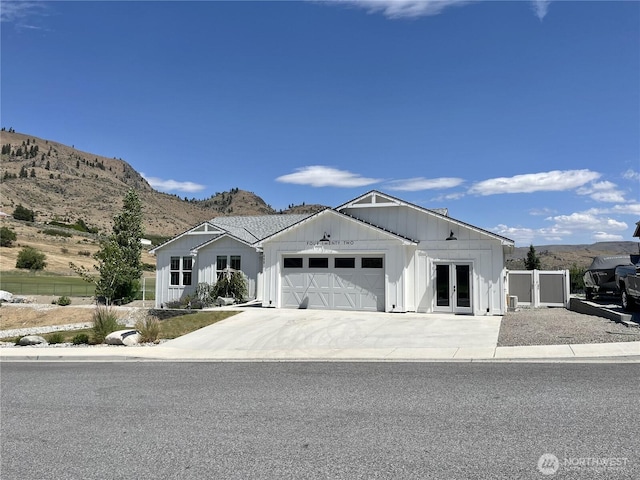 422 Sunny Brooke Ln, Chelan, WA 98816 - modern farmhouse featuring french doors, board and batten siding, an attached garage, a mountain view, and driveway