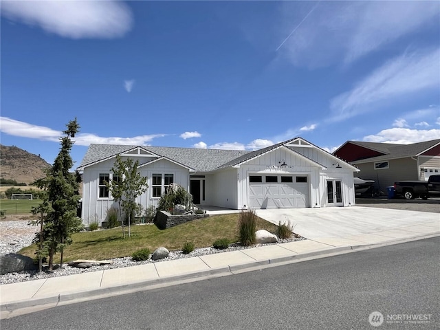 422 Sunny Brooke Ln, Chelan, WA 98816 - view of front of home featuring board and batten siding, an attached garage, concrete driveway, and a front lawn
