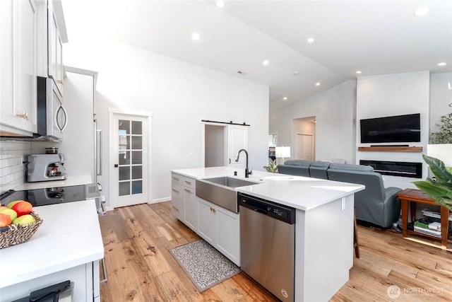 422 Sunny Brooke Ln, Chelan, WA 98816 - kitchen featuring stainless steel appliances, open floor plan, white cabinetry, light countertops, and vaulted ceiling