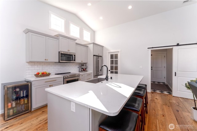 422 Sunny Brooke Ln, Chelan, WA 98816 - kitchen with high quality appliances, beverage cooler, high vaulted ceiling, a breakfast bar area, and a kitchen island with sink