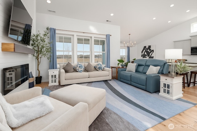 422 Sunny Brooke Ln, Chelan, WA 98816 - living room featuring a chandelier, a fireplace, wood finished floors, recessed lighting, and vaulted ceiling