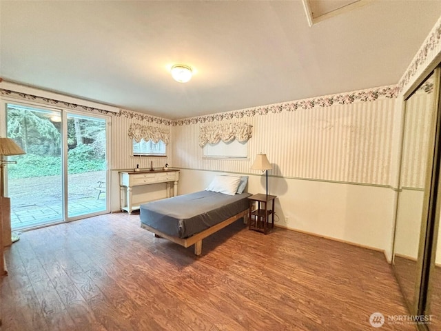 bedroom with wood finished floors and access to exterior