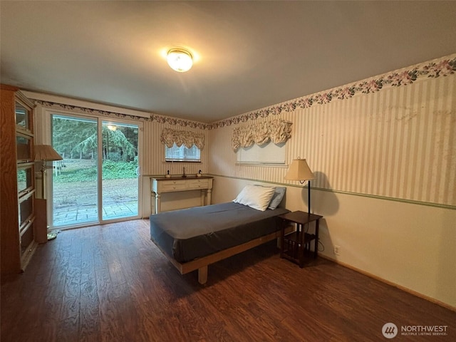 bedroom featuring access to outside, baseboards, and wood finished floors