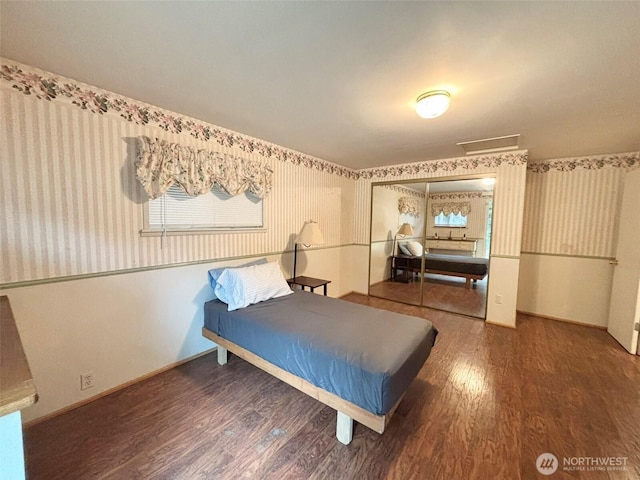 bedroom with a closet, baseboards, and wood finished floors