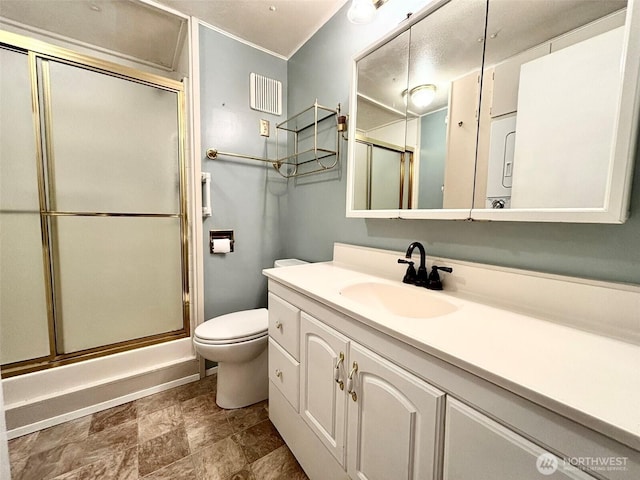 full bath with a shower with door, visible vents, toilet, stone finish flooring, and vanity