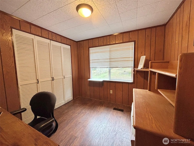 office with wood finished floors, visible vents, and wooden walls