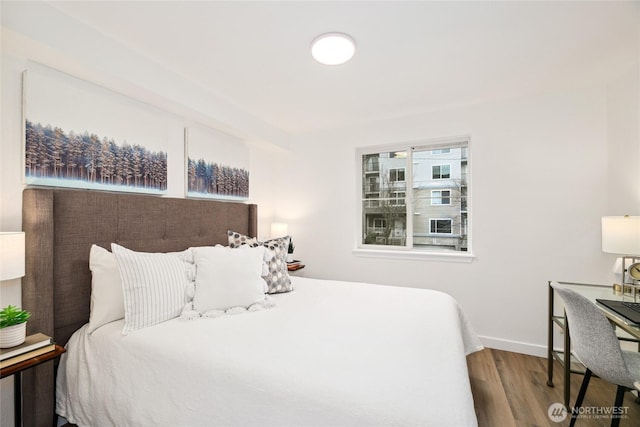 bedroom with baseboards and wood finished floors