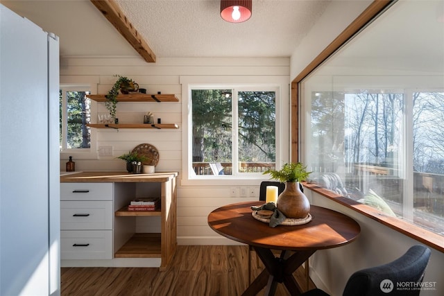 sunroom featuring a healthy amount of sunlight and beamed ceiling