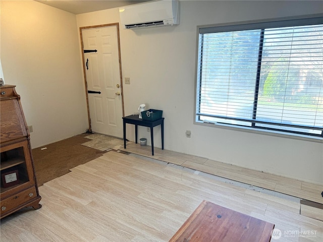 interior space with a wall mounted air conditioner and wood finished floors