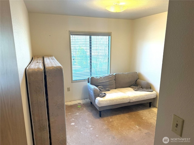 living area featuring unfinished concrete flooring