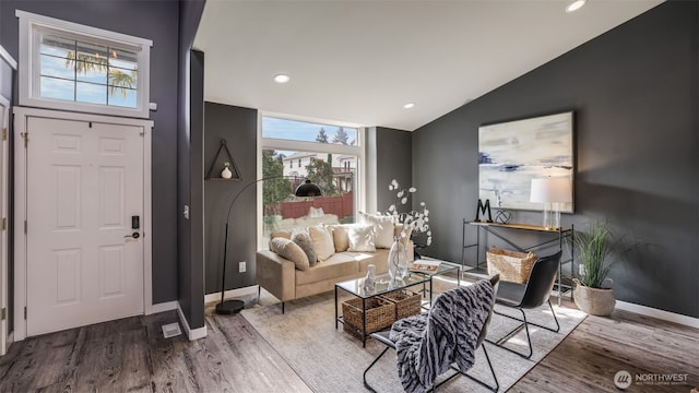 living room featuring lofted ceiling, baseboards, wood finished floors, and recessed lighting