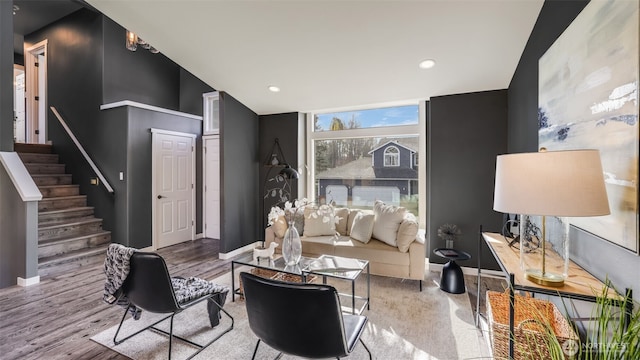 living area featuring stairway, wood finished floors, and baseboards