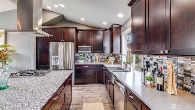 kitchen featuring island range hood, a sink, vaulted ceiling, appliances with stainless steel finishes, and tasteful backsplash