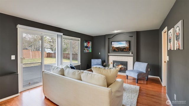 living room featuring a fireplace, wood finished floors, and baseboards