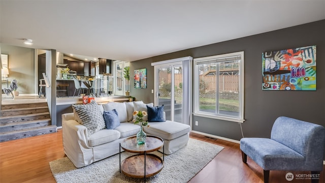 living room with visible vents, baseboards, and wood finished floors