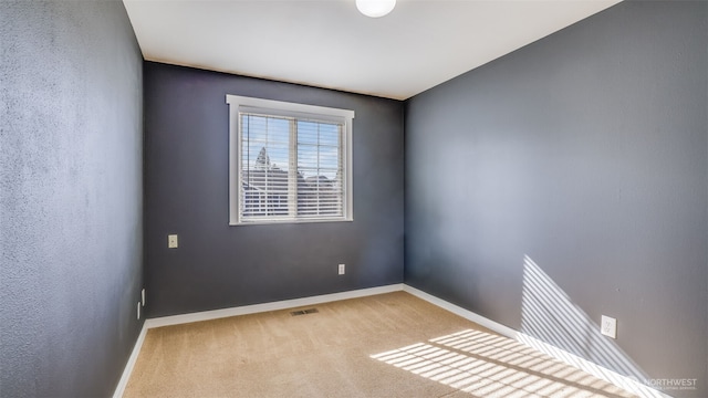 carpeted spare room with baseboards and visible vents