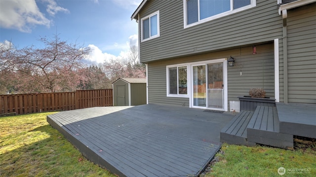 deck with an outbuilding, fence, a storage shed, and a lawn