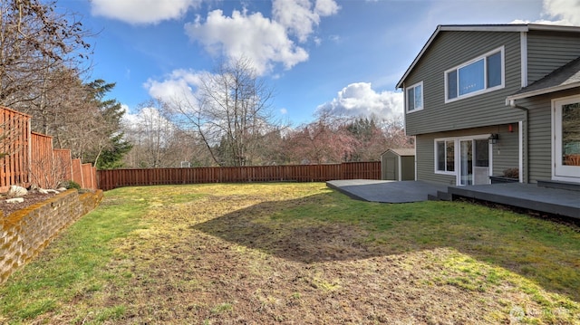 view of yard with an outbuilding, a fenced backyard, and a storage unit