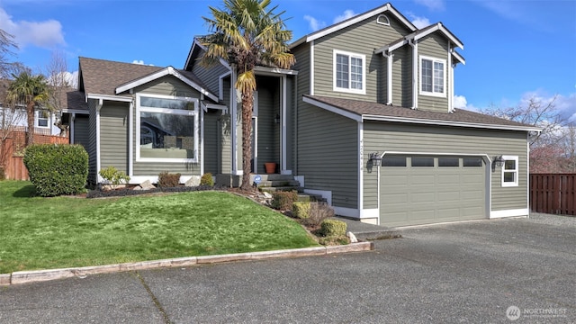 view of front of house featuring roof with shingles, an attached garage, a front yard, fence, and driveway