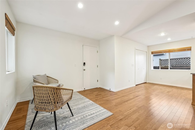 living area with recessed lighting, baseboards, and wood finished floors