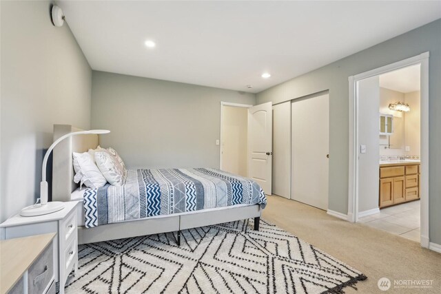 bedroom featuring baseboards, light carpet, recessed lighting, ensuite bathroom, and a closet