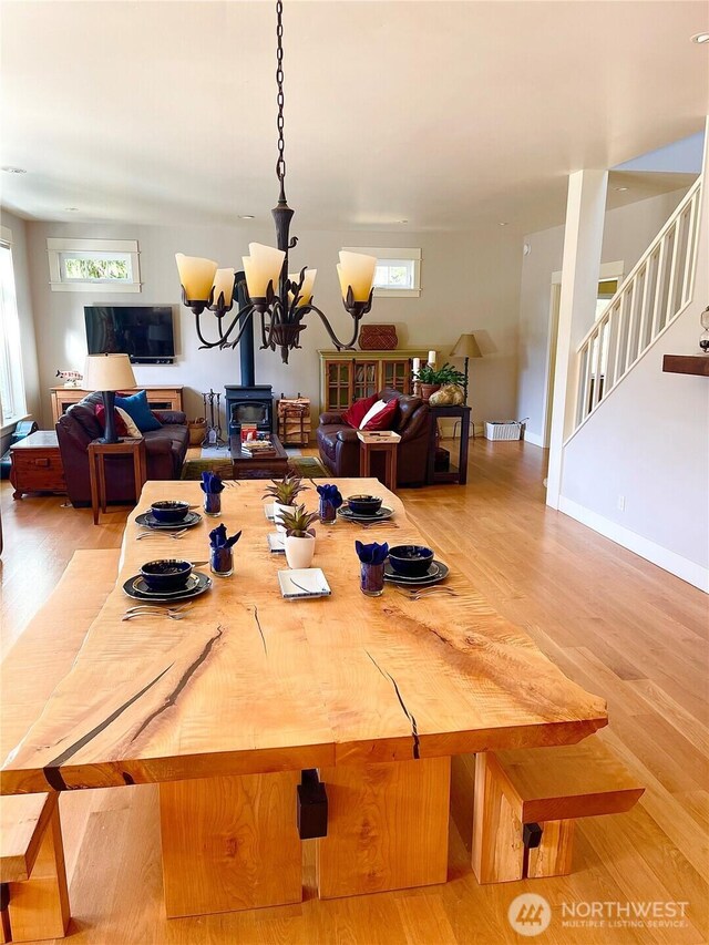 dining room with light wood-style floors, a chandelier, plenty of natural light, and stairway