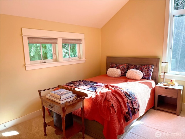 carpeted bedroom with vaulted ceiling and baseboards